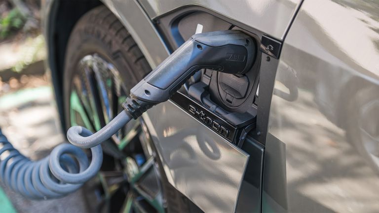 A close-up of the car being plugged into the charging station