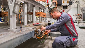 A maintenance technician can be seen working on a robot