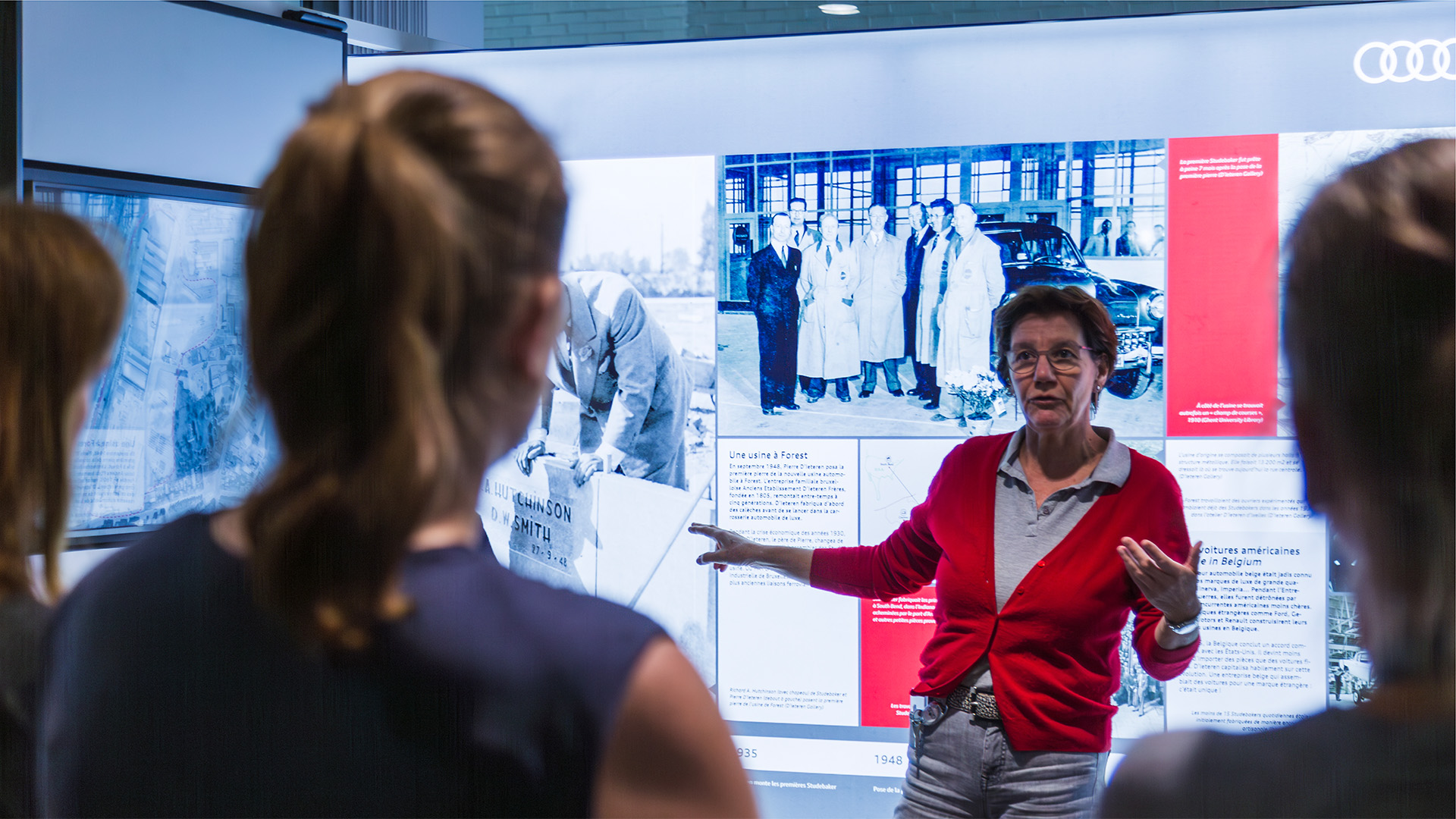 A woman explaining the history of Audi Brussels