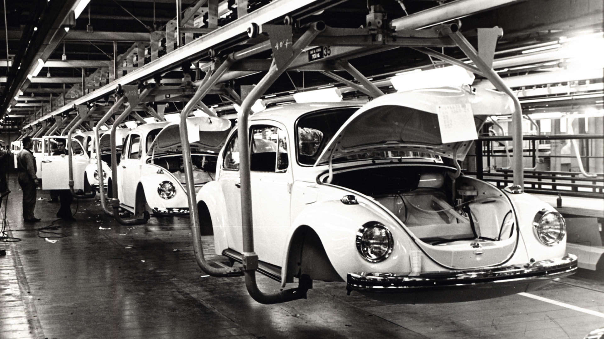 A black and white photo representing the old assembly line from the years when the Beetle was produced