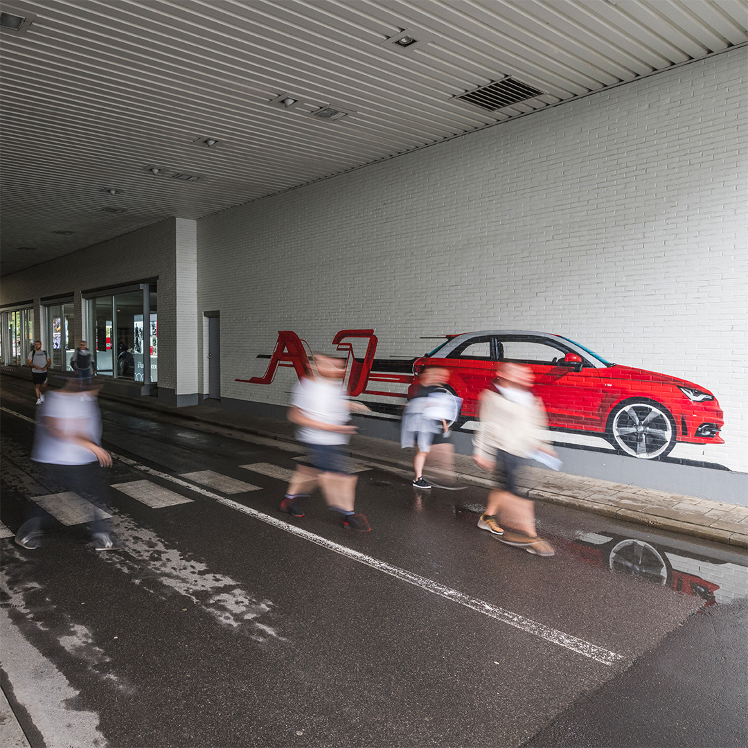 De foto van 6 arbeiders, met de tag van de rode Audi A1 erachter