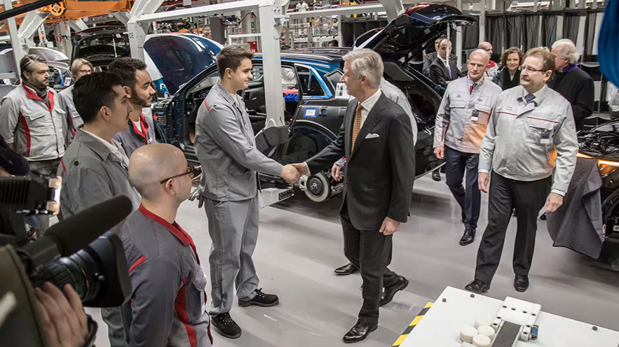 His Majesty the King Philippe shakes hands with a worker in an Audi Brussels production hall