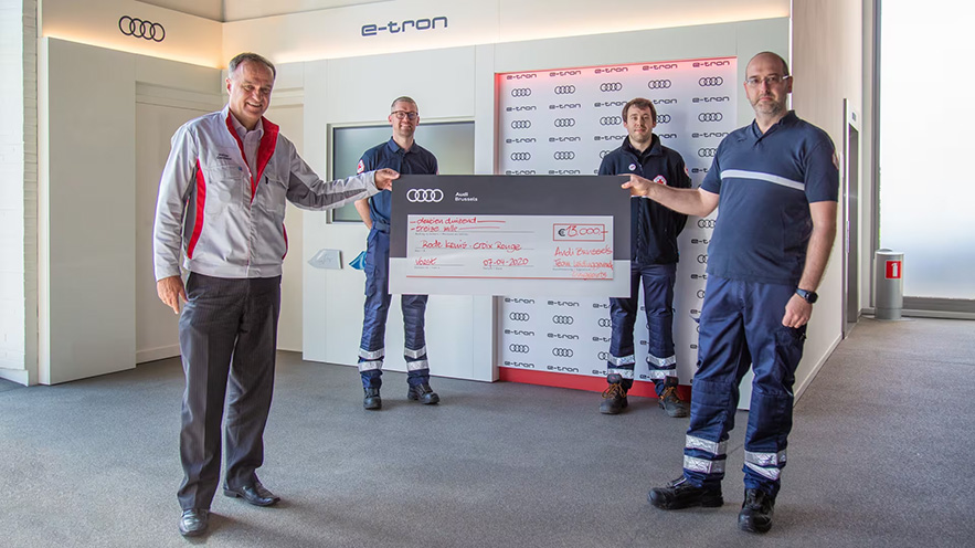 Red Cross employees receive a cheque from the CEO