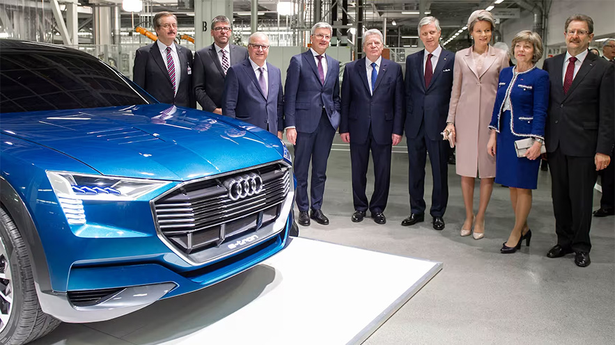 Their Majesties the King and Queen of Belgium standing next to an Audi e-tron concept car in the Brussels pland